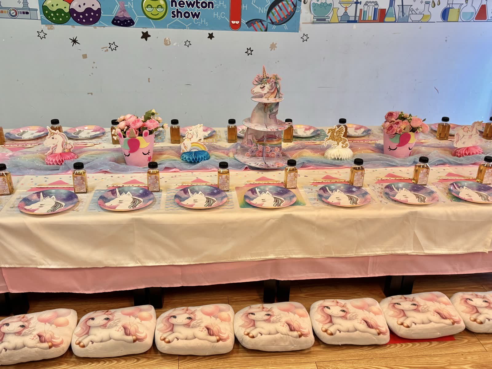 Unicorn-themed dessert table with tiered cake at a Newtonshow party