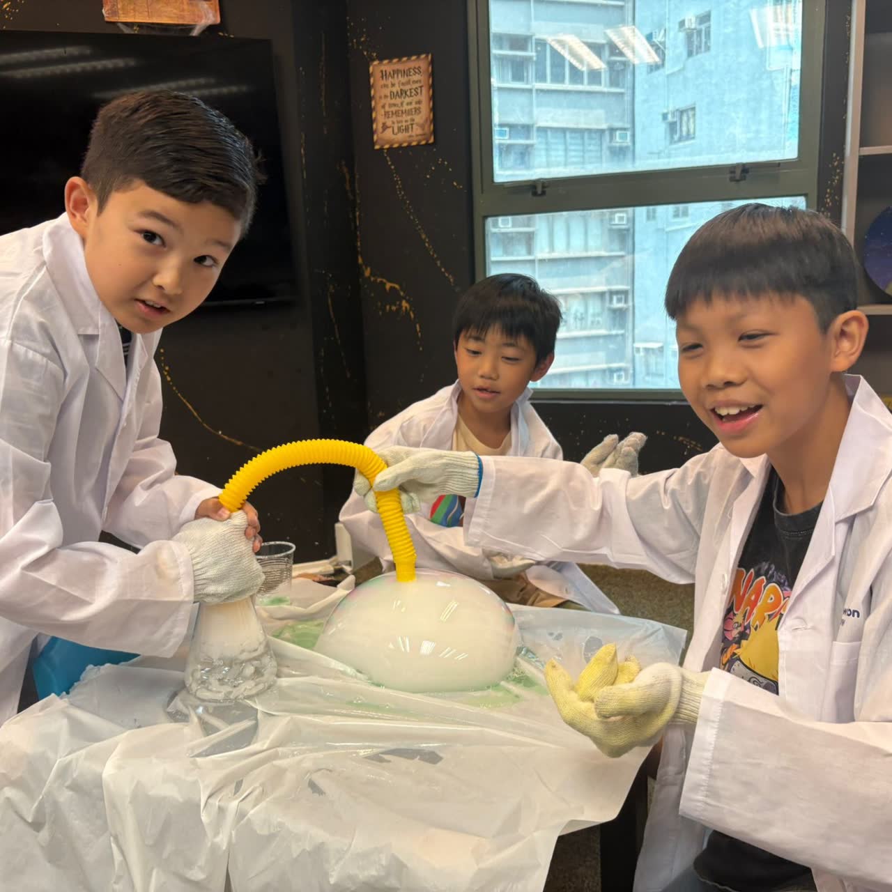 Boys stretching a giant dry-ice bubble at a Newtonshow science camp