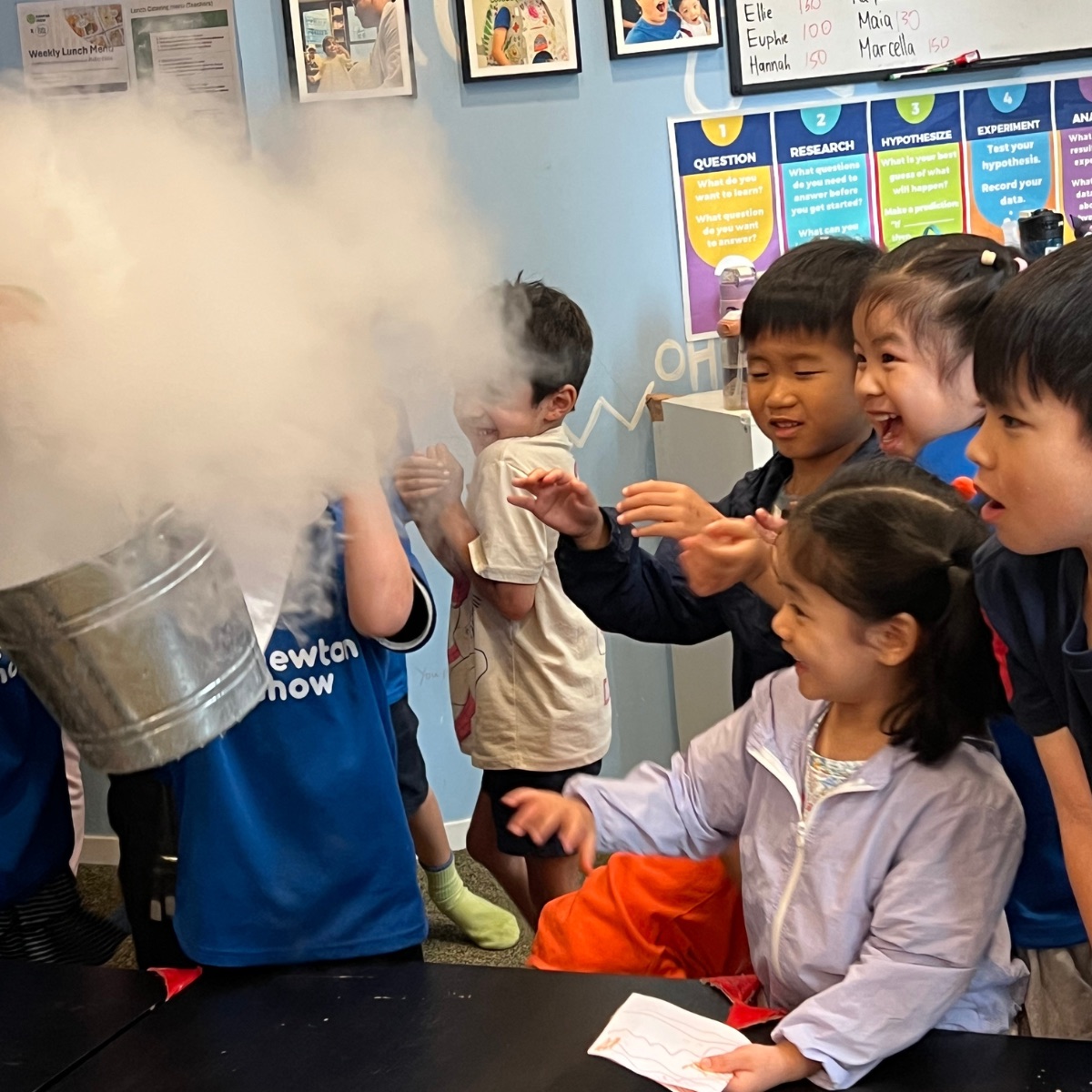 Children reaching into a huge cloud of dry-ice fog at a Newtonshow Hong Kong science camp