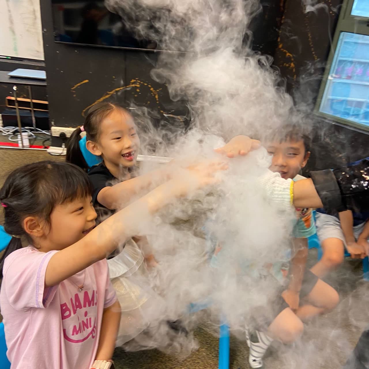 Children reaching into a cloud of dry-ice fog at a Newtonshow wizard party