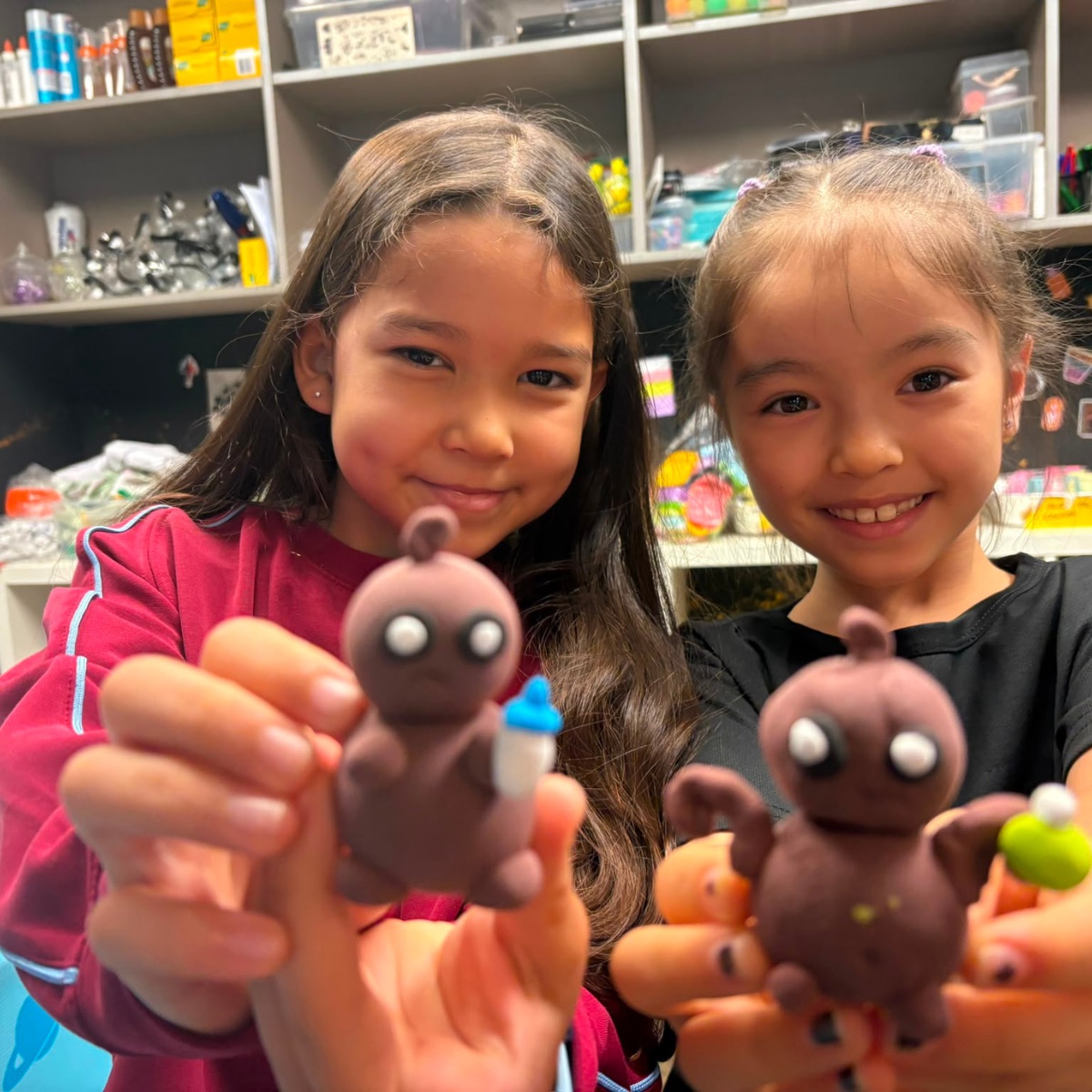 Two girls showing the clay characters they modelled at Newtonshow