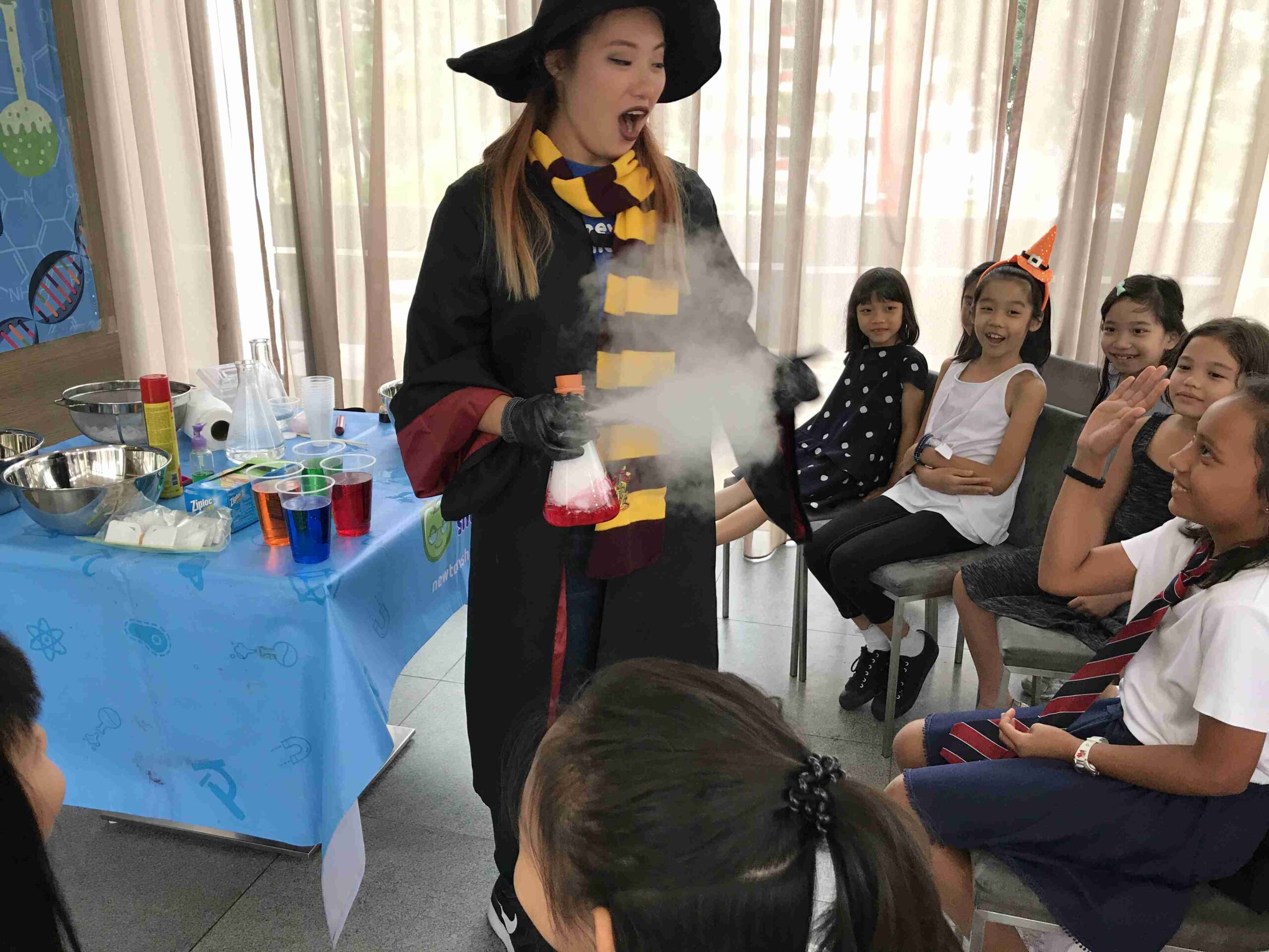 Newtonshow host in wizard costume creating smoke effects at a birthday party