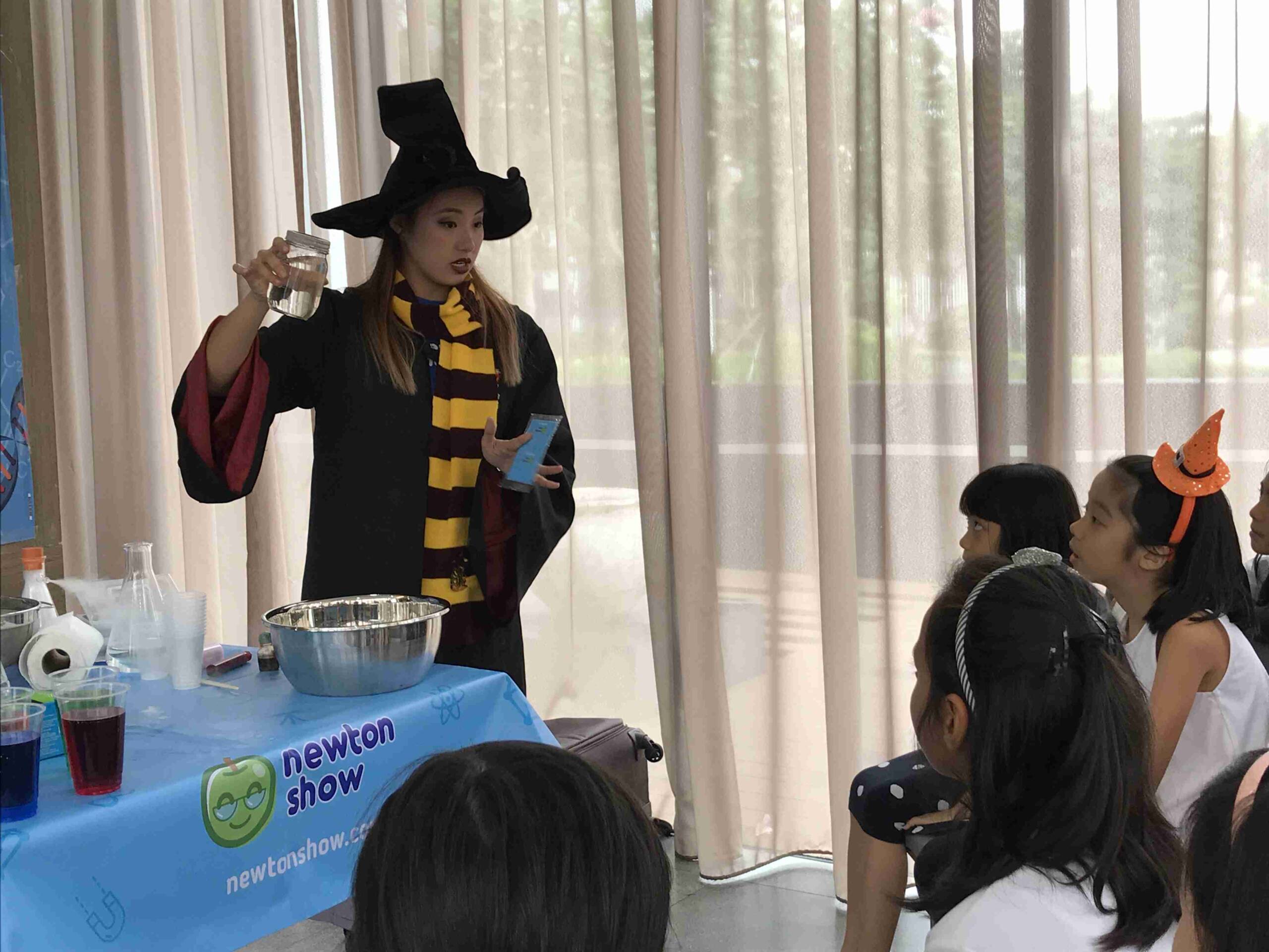 Wizard-costumed host pouring a bubbling potion for party guests