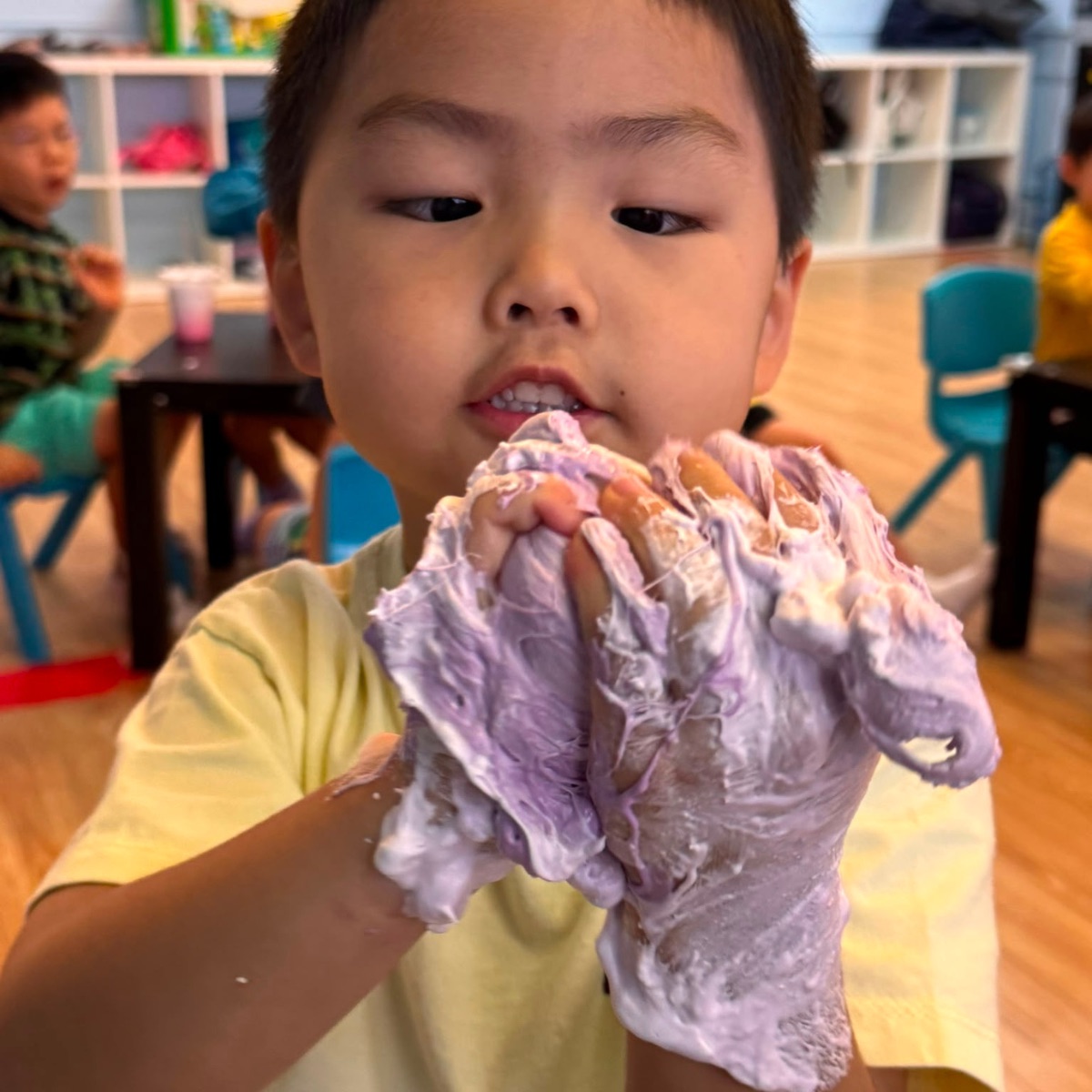 Child stretching purple slime he made at a Newtonshow camp