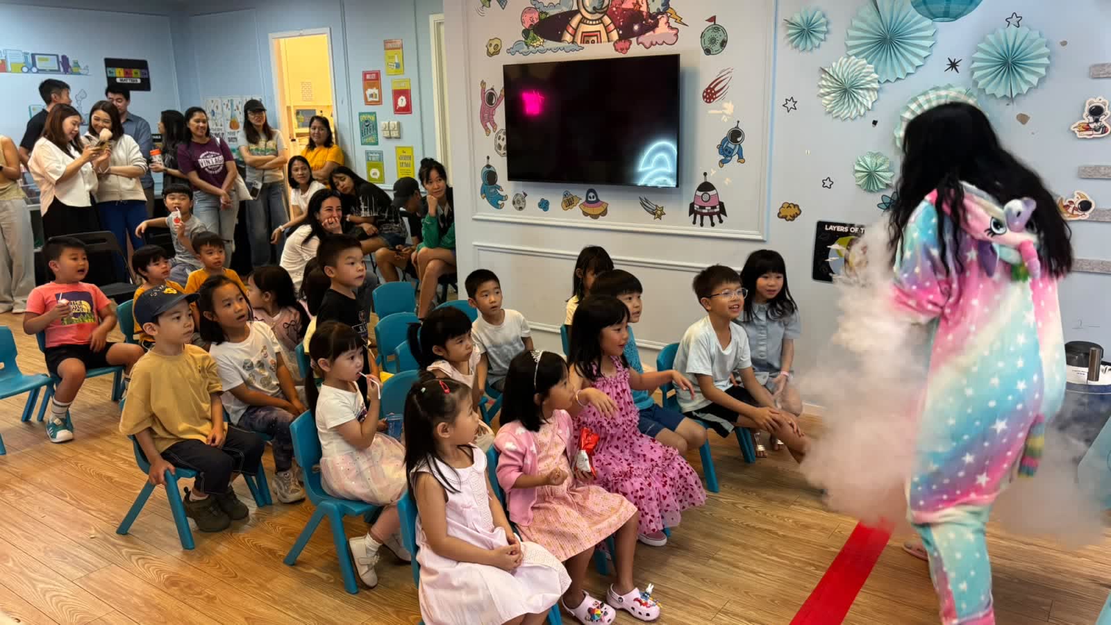 Children reaching into a dry-ice fog cloud at a themed Newtonshow birthday party