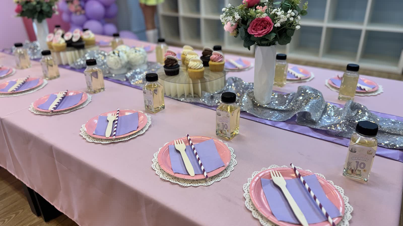 Spa party dessert table with cupcakes, flowers and beauty-themed treats