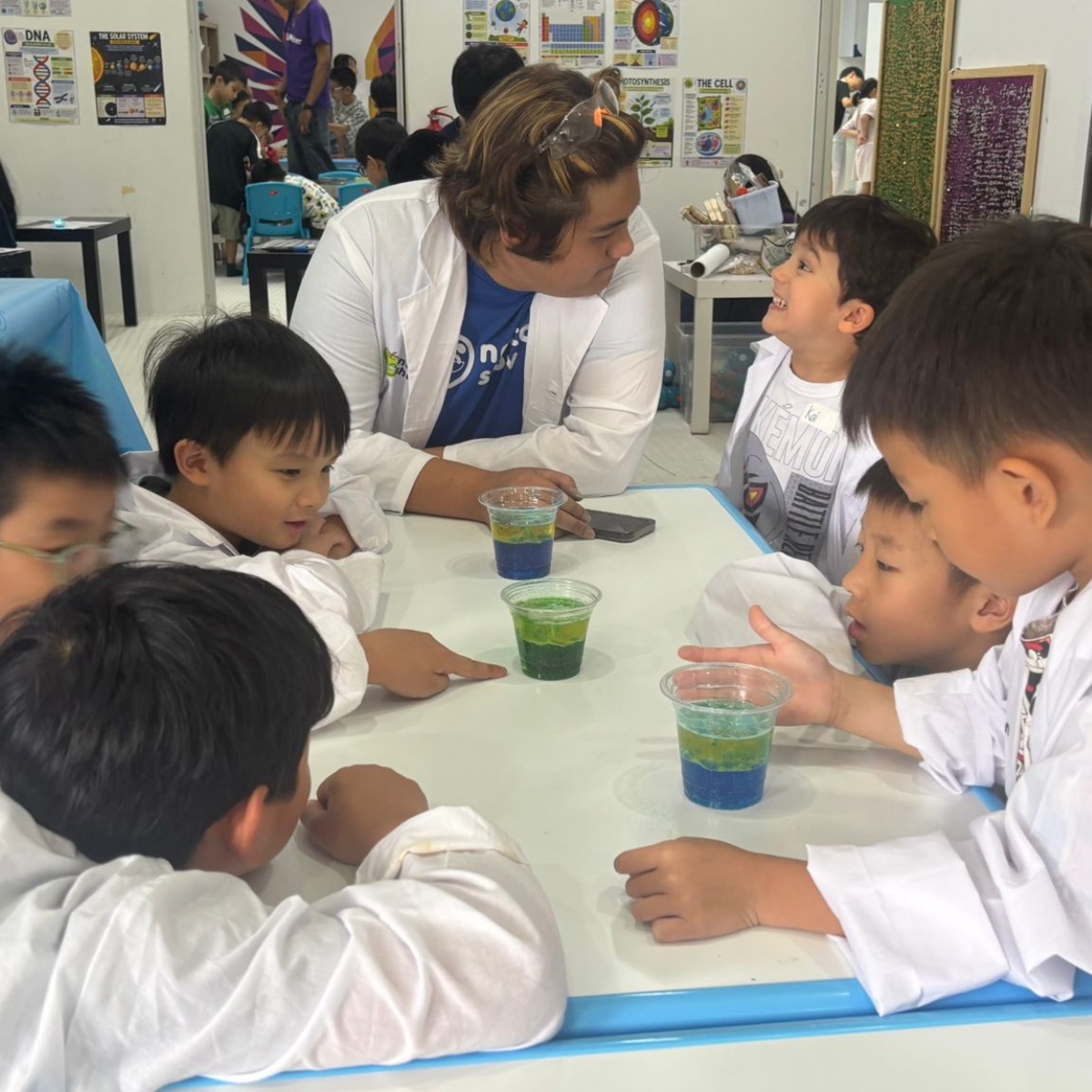 Teacher leading a green potion experiment with young scientists at Newtonshow